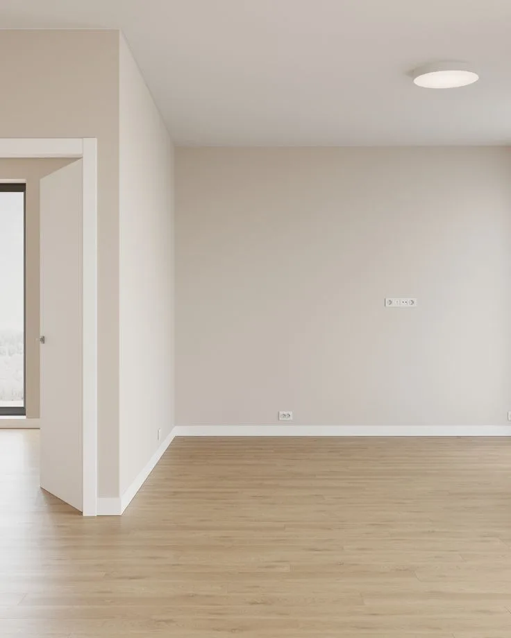 Dormitorio vacío con suelo de tarima y paredes pintadas con acabado premium por empresa de pintores en Madrid Capital.